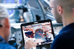 Beratungsgespräch mit Tablet, abgebildeter Karosse und zusätzlichen Zeichnungen